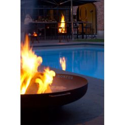 Pebetero de leña BonBowl Plus de Bonfeu junto a una piscina