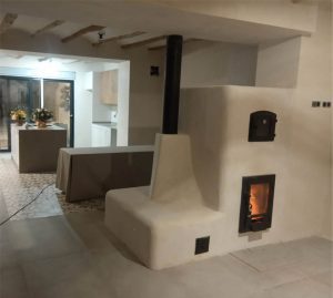 Bonita estufa de inercia rocket, esculpida con banco y acabado en cal.