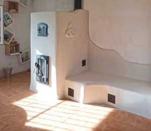 Ejemplo de estufa de inercia rocket con banco y horno, acabado en cal