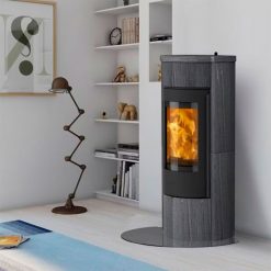 Foto de ambiente de la estufa de inercia de leña Prestige Basic M de Lotus forrada en piedra esteatita Indian Night. Certificada para Passivhaus